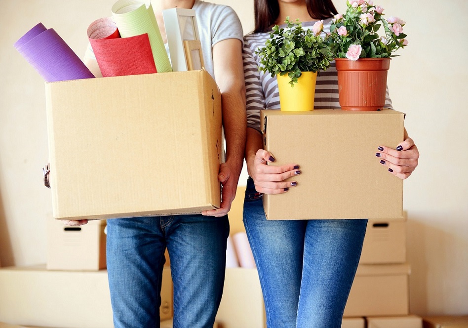 Couple qui porte des cartons de déménagement