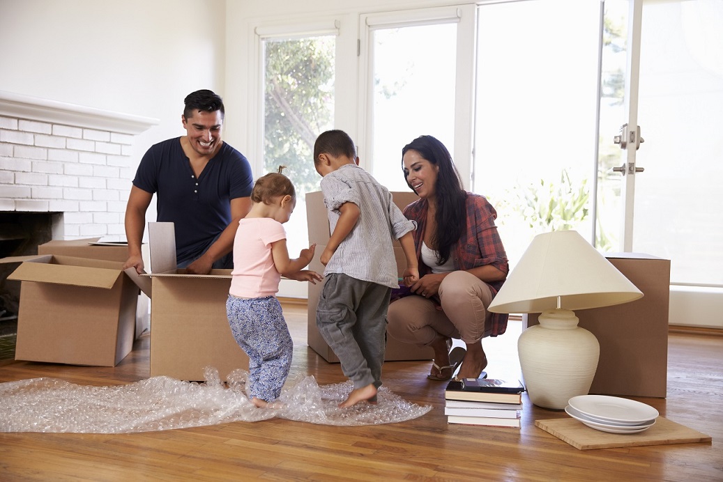 Happy family unpacking moving boxes