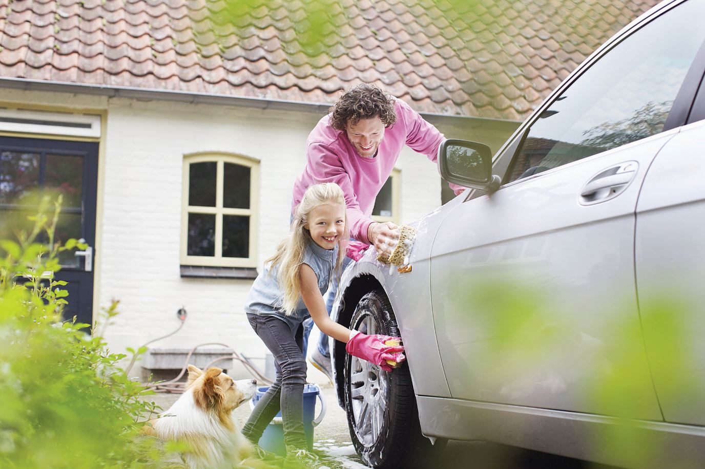 Father and daughter washing a car