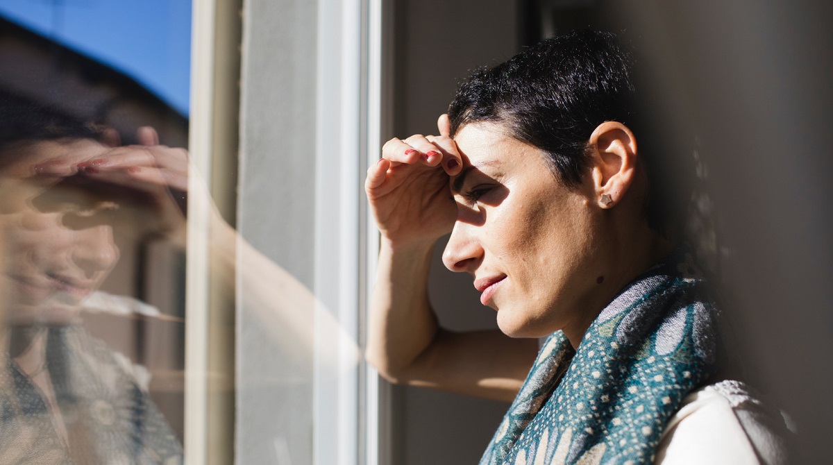 Femme qui regarde par la fenetre