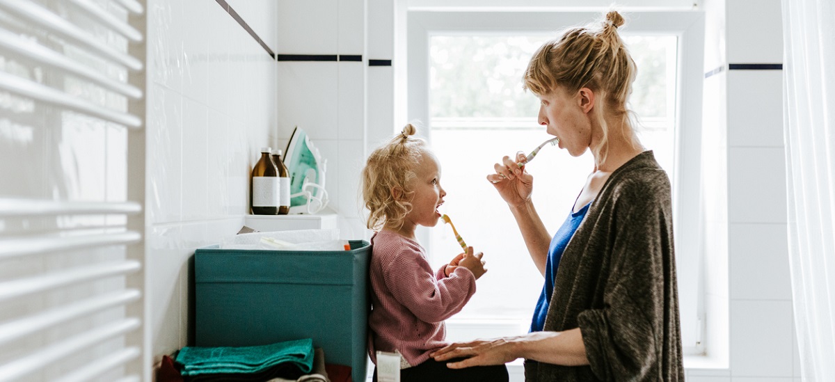 Woman and daughter brushing teeth