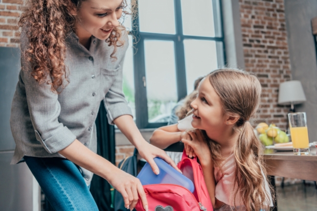 Maman qui prépare sa fille pour aller à l'école