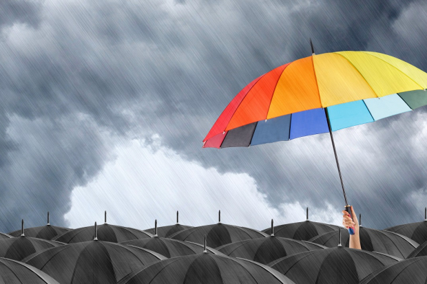 Rainbow umbrella stand out in a sea of black umbrellas