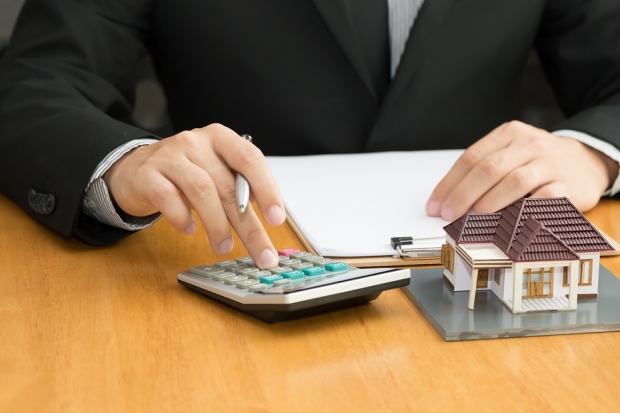 Man using a calculator for his mortgage insurance