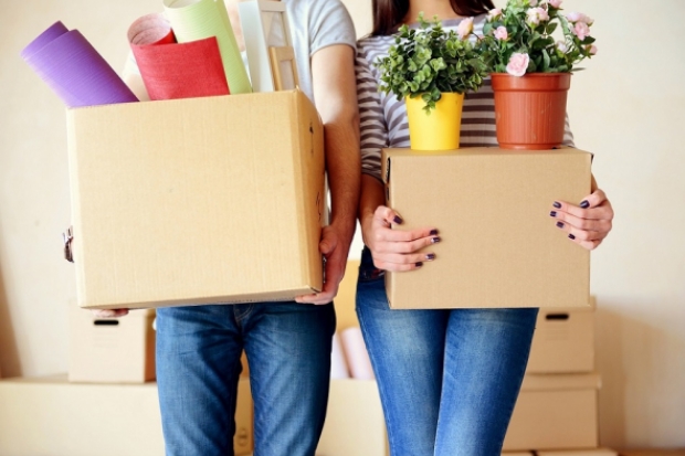 Couple holding moving boxes