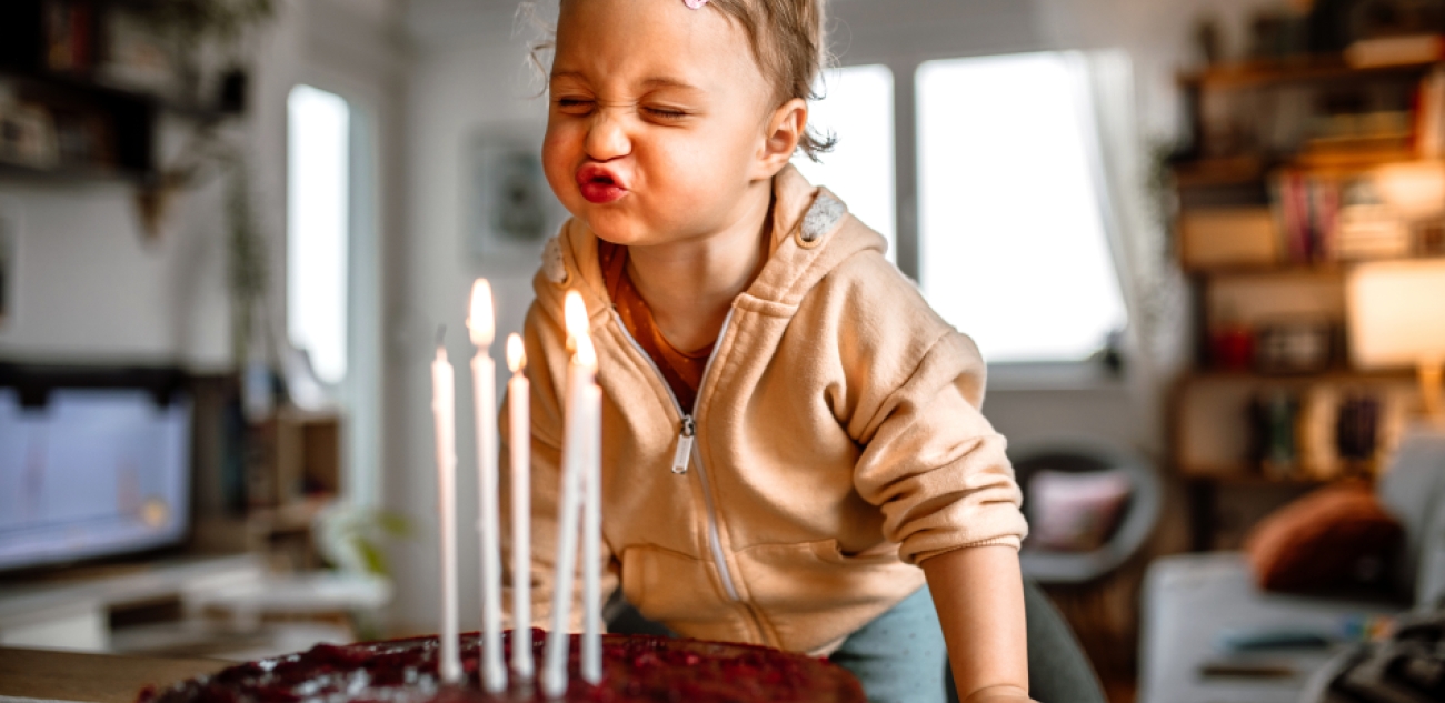 Petite fille souffle bougies gâteau anniversaire
