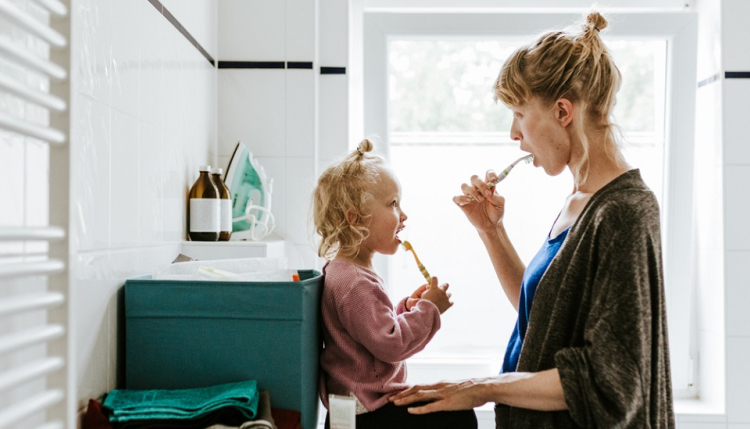 Woman and daughter brushing teeth