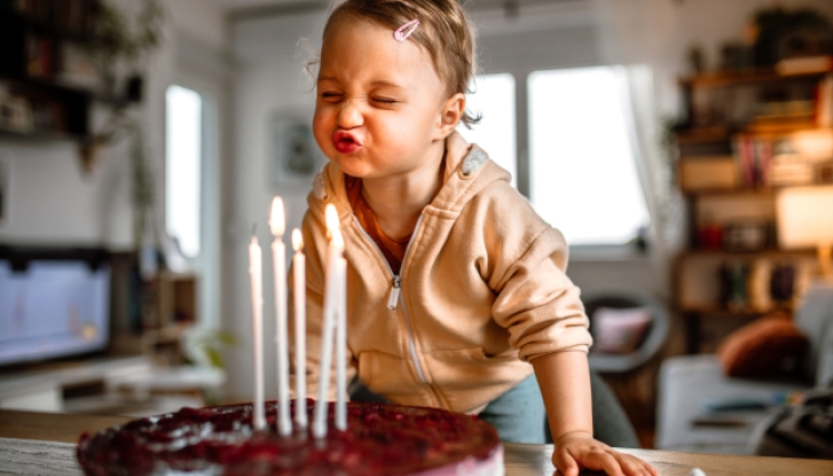 Toddler blowing birthday candles